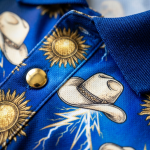 Wrestling polo shirt fabric macro — cream gold lightning print detail