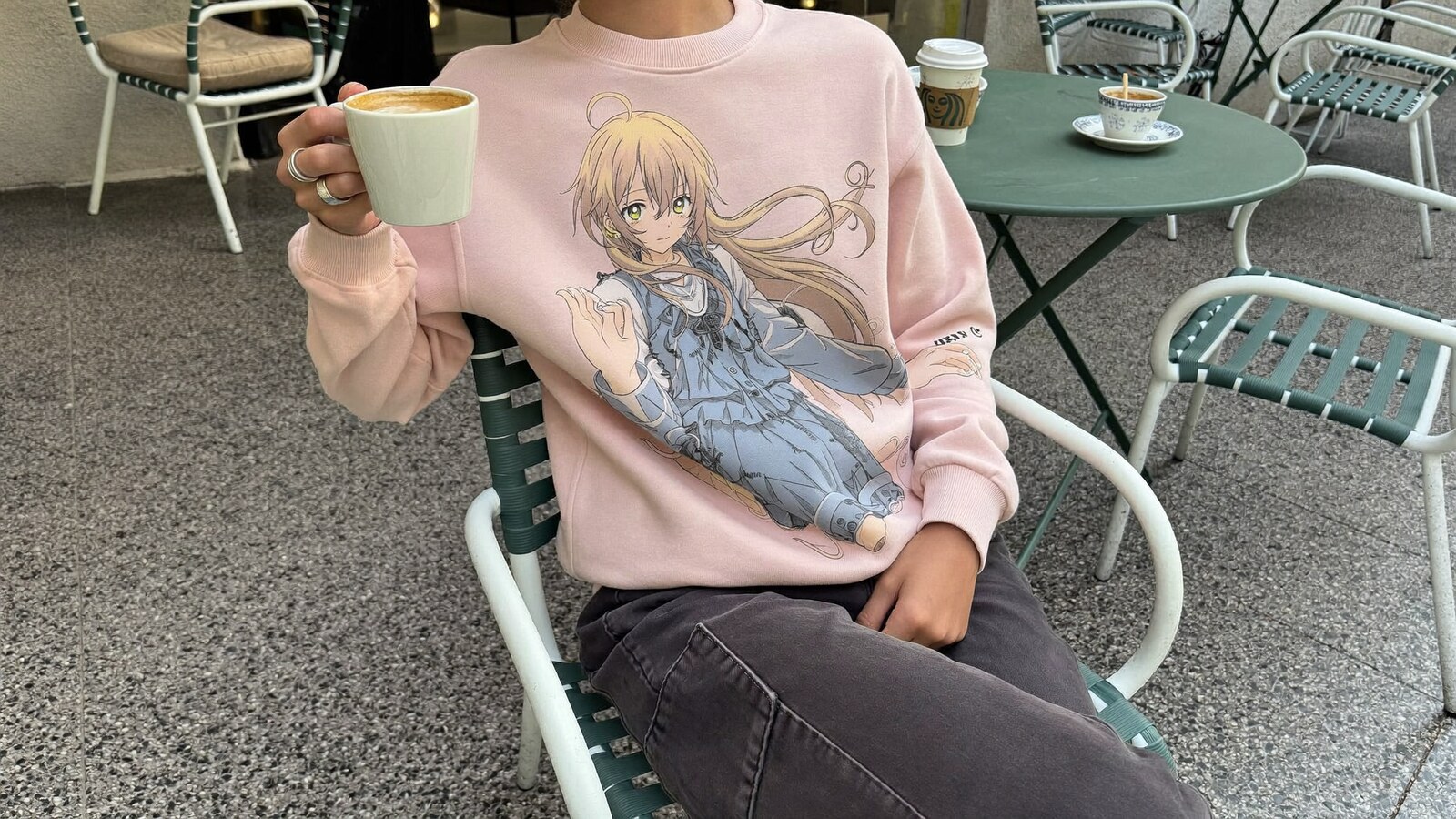 Anime-inspired embroidered sweatshirt styled in a natural daylight scene