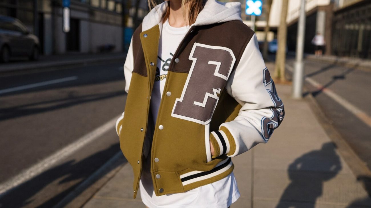 Person wearing an anime-inspired varsity jackets in an editorial scene