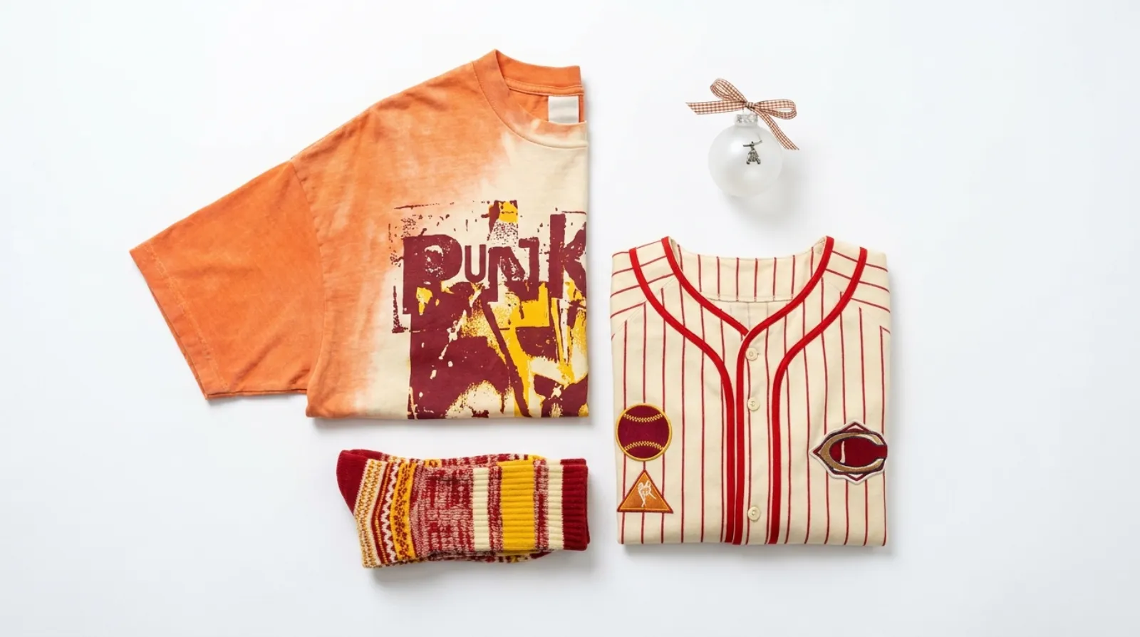 Flat-lay of Chainsaw Man merch including a Pochita oversized shirt, a baseball jersey, socks and a glass ornament