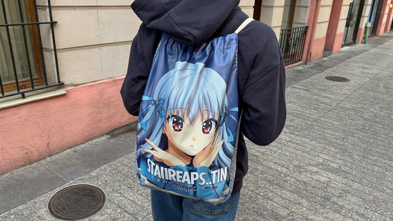 Person wearing an anime-inspired drawstring bags in an editorial scene