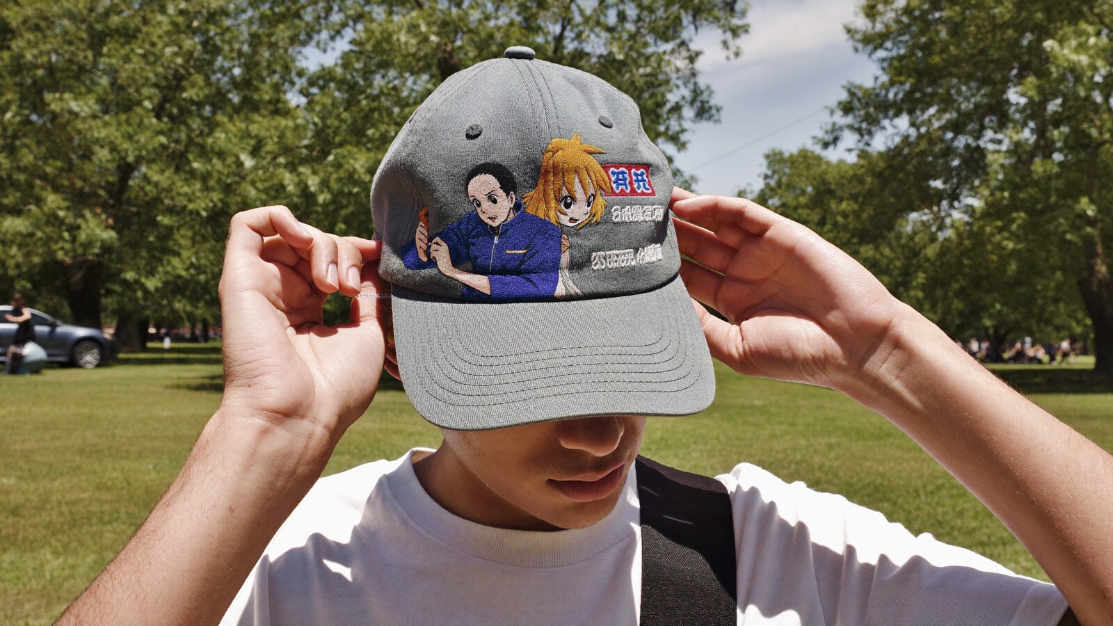 Anime-inspired embroidered baseball cap styled in a natural daylight scene