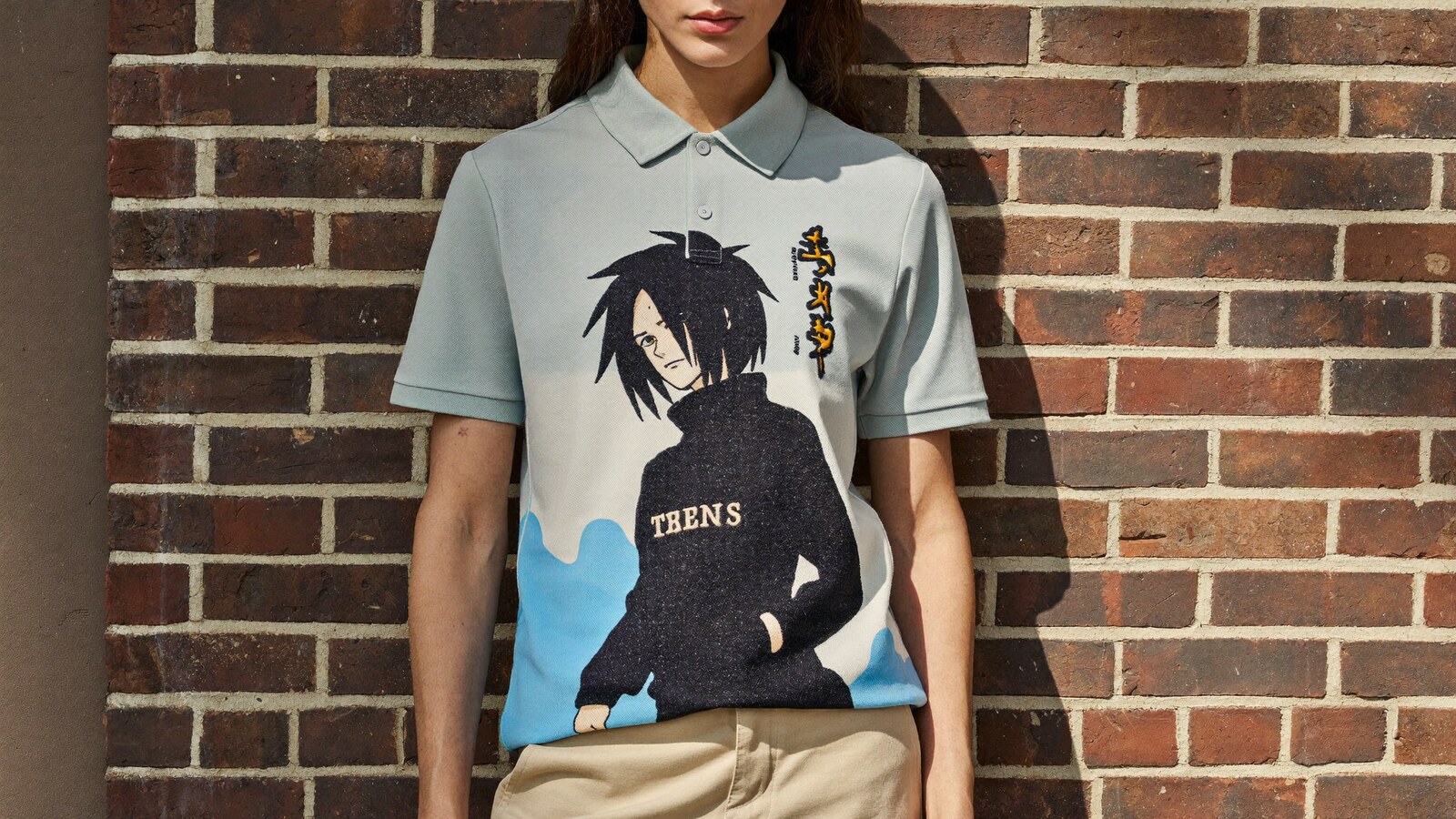 Person wearing an anime-inspired embroidered polo shirt in an editorial scene