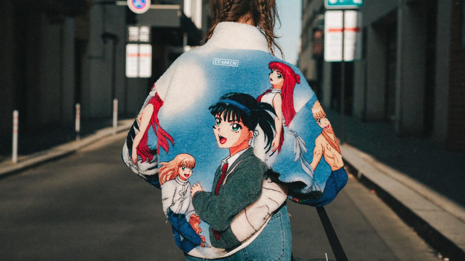 Person wearing an anime-inspired fleece bomber jacket in an editorial scene
