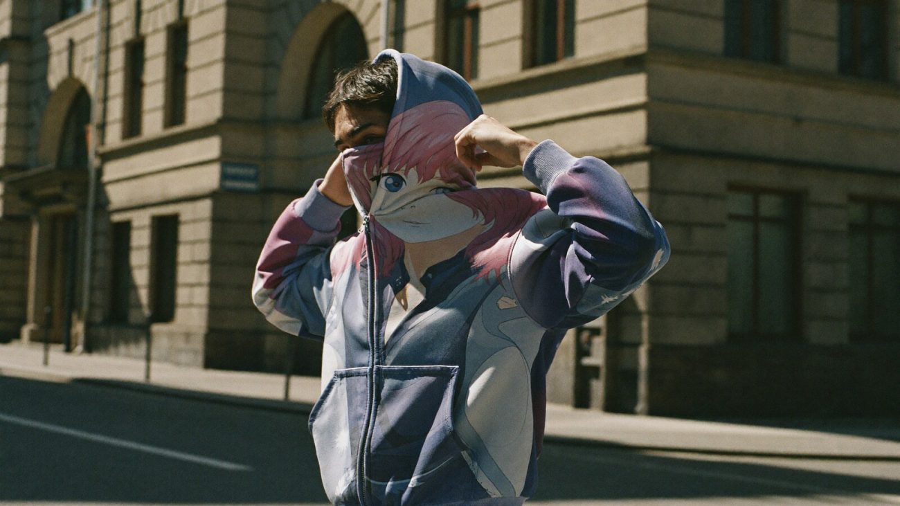 Person wearing an anime-inspired full face zip hoodie in an editorial scene