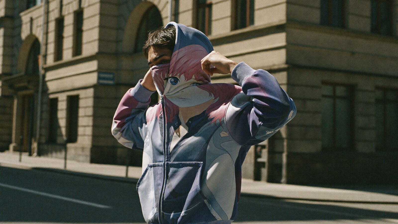 Person wearing an anime-inspired full face zip hoodie in an editorial scene