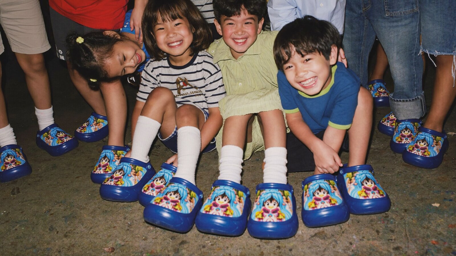 Anime-inspired kids clogs in a social or layered scene with friends