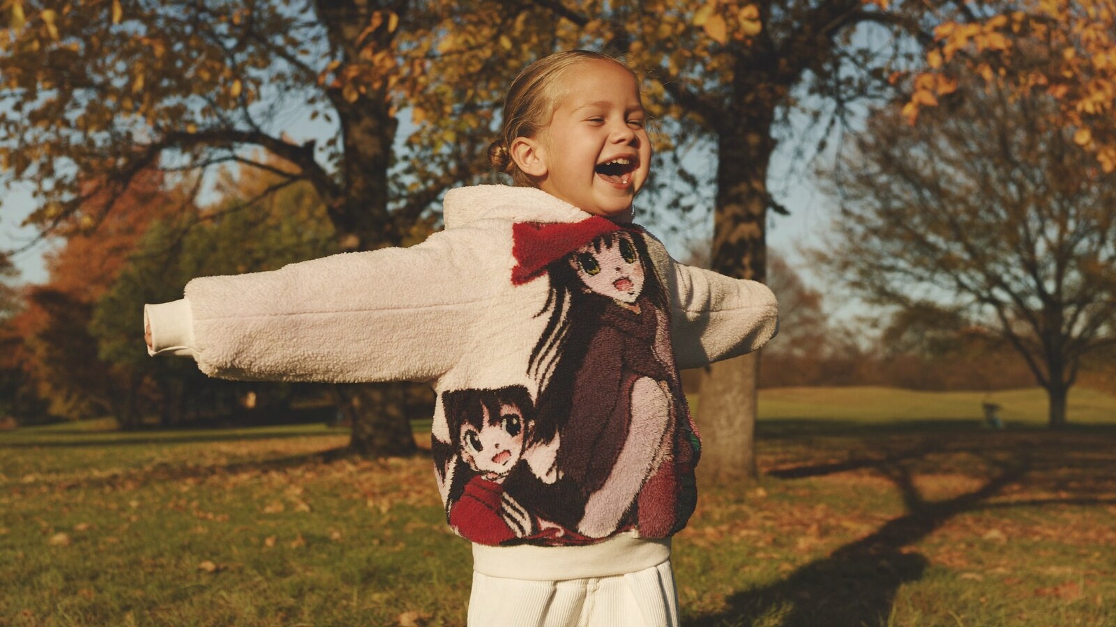 Person wearing an anime-inspired kids hoodie in an editorial scene