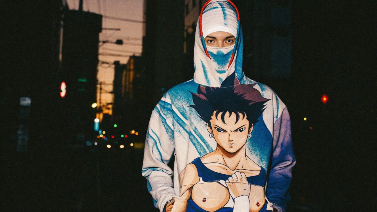 Person wearing an anime-inspired masked hoodie in an editorial scene