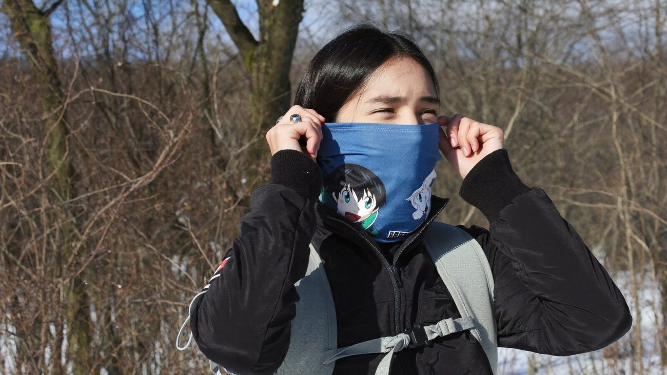 Person wearing an anime-inspired neck gaiters in an editorial scene