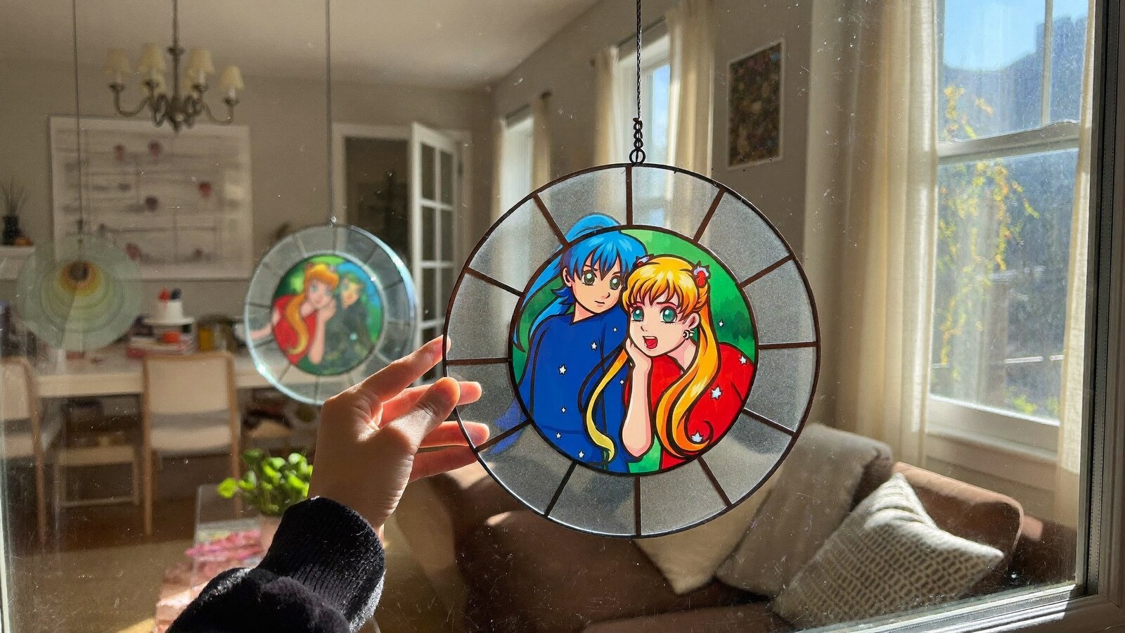 Anime-inspired stained glass suncatchers styled in a natural daylight scene