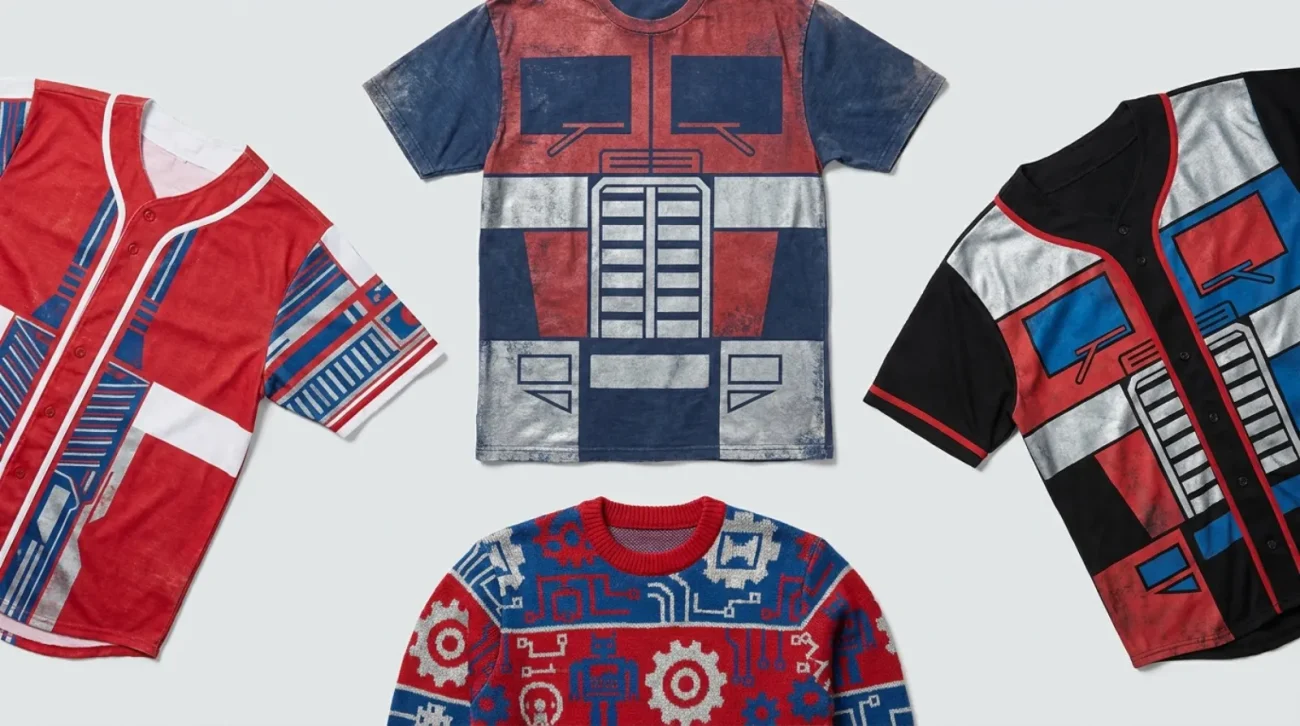 Transformers shirt flat lay with vintage graphic tee, Autobot and Decepticon faction jerseys, and a holiday sweater