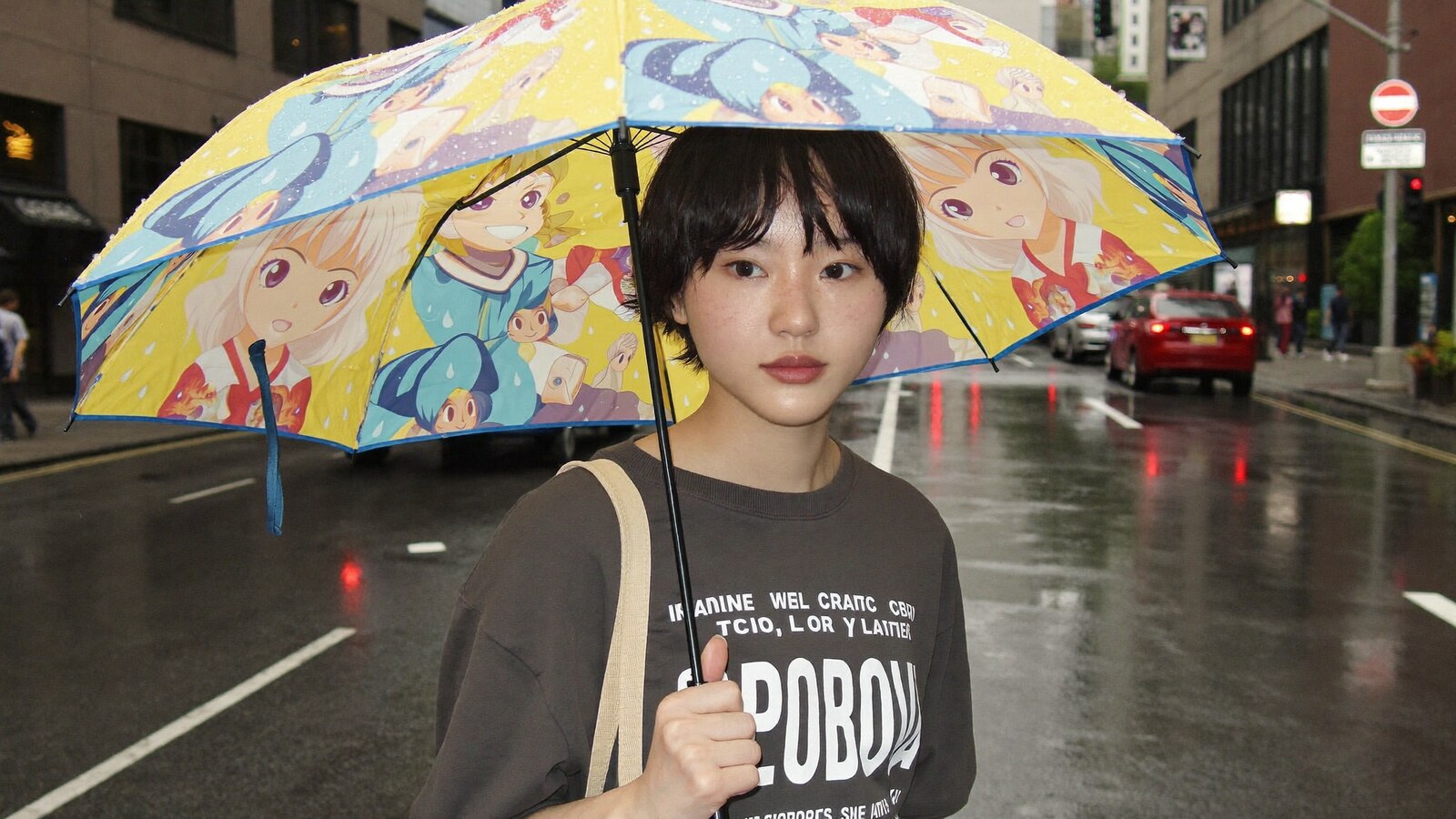 Person wearing an anime-inspired umbrella in an editorial scene