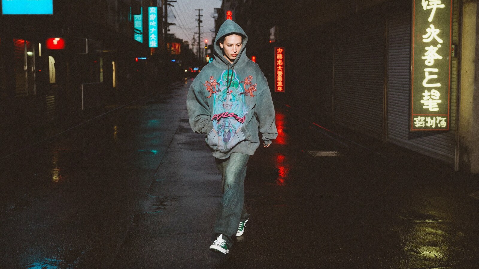 Person wearing an anime-inspired vintage hoodie in an editorial scene