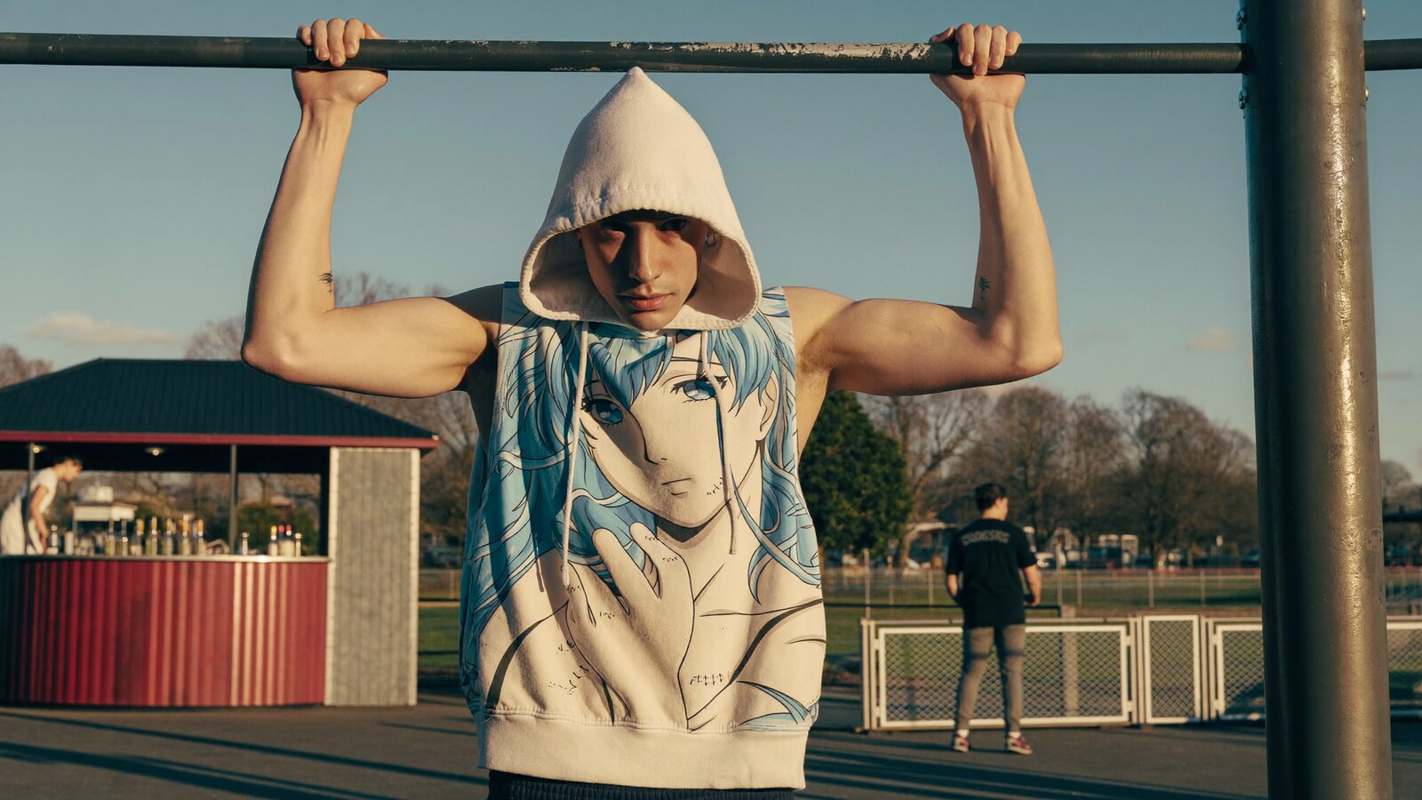 Anime-inspired workout & sleeveless hoodies styled in a natural daylight scene