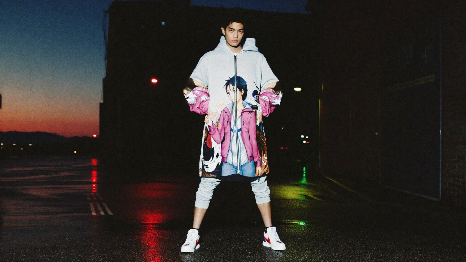 Person wearing an anime-inspired zip hoodie jackets in an editorial scene